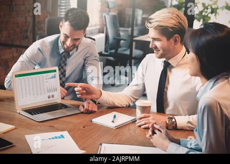 Group of young business people with laptop. Financial and accounting discussion on business meeting Stock Photo