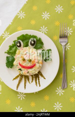 Creatively decorated octopus salad. Children's menu on a green background. Stock Photo