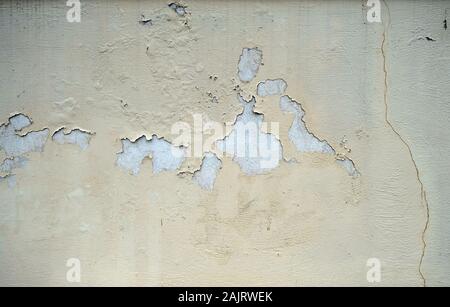 Painted and faded wall texture grunge background. Light yellow color exterior building facade detail Stock Photo