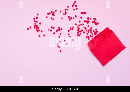 Opened red envelope and many felt hearts on pink background with place for text. Love letter mail correspondence relationship. Valentines day concept. Stock Photo