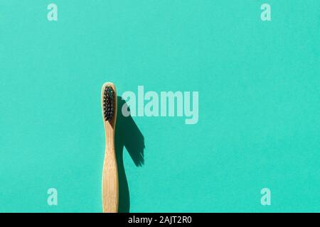 Eco-friendly bamboo toothbrush made from biodegradable materials on green paper background Stock Photo