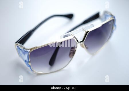 Stylish sunglasses lie on a white table Stock Photo