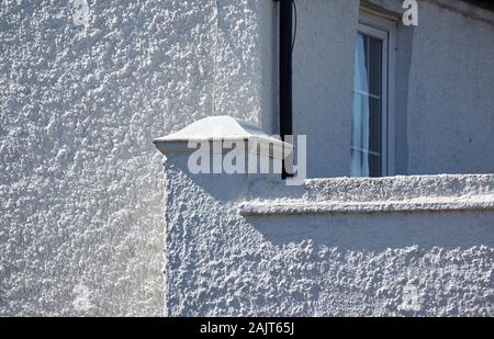 White pebble dash wall in oblique sunlight Stock Photo