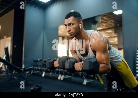 Man doing exercise with dumbbells on the bench Stock Photo