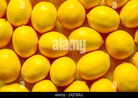 Top view many ripe lemons on a yellow surface, background or concept Stock Photo