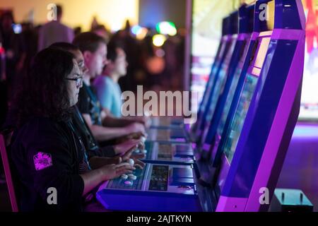 Washington, D.C. / USA - January 5, 2019:  Young adults gather around in an arcade to play a variety of different computer and video games with friends on a Saturday night. Stock Photo