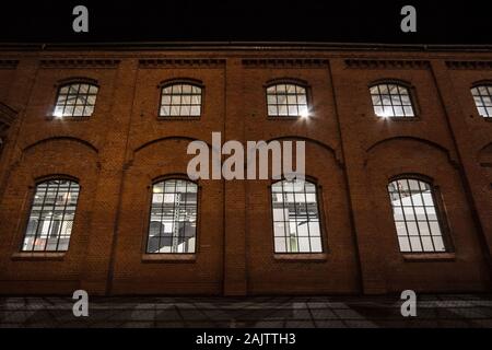Facade of a vintage old red brick warehouse, used from an Industrial Revolution Era facotry plant, with large windows, showing a renovated and reconst Stock Photo