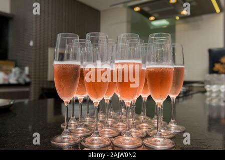 Lined crystal flutes filled with champagne on black granite counter for gold anniversary celebration. Toast of the 50 years of marriage. Golden weddin Stock Photo