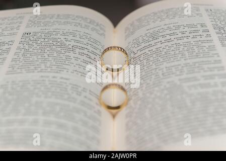 Wedding rings on a holy bible 'Bíblia Sagrada'. Concept of union, love, companionship, faithfulness. Religious union. Selective focus. Stock Photo