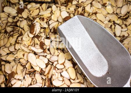 Sliced Almonnd nuts in dispenser with a scoop Stock Photo