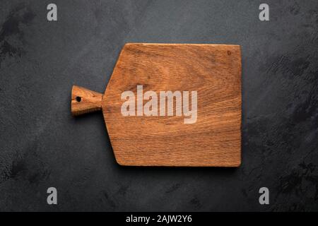 Chopping cutting board on black concrete background, copy space for text, design, menu, recipe and so on. Top view Stock Photo