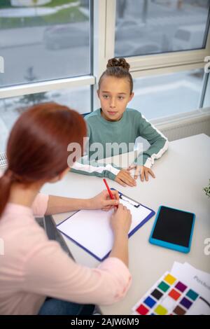 Teacher working with her young student during the individual lesson Stock Photo