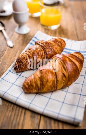 traditional french breakfast, crissant and coffee and juice on wood table Stock Photo