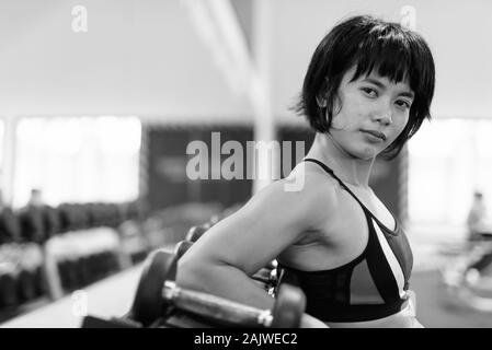 Young beautiful Asian woman working out at the gym Stock Photo