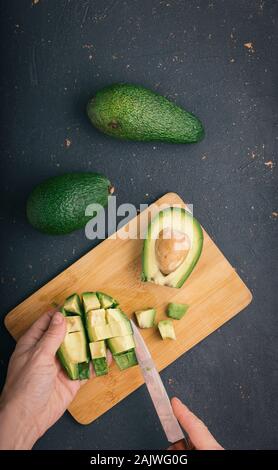 Woman is cleaning avocado for salad. Stock Photo