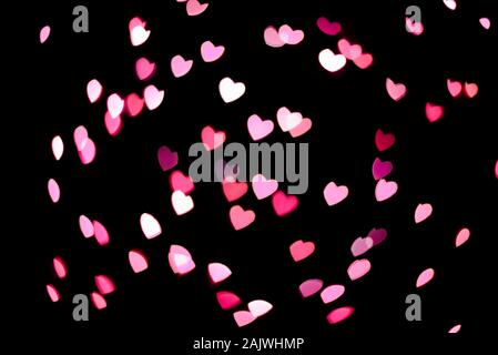 A lot of pink hearts flying on black background Stock Photo