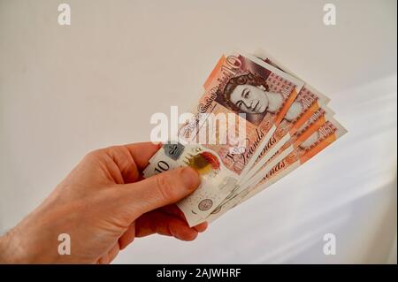 Male holding four crisp polymer ten pound notes. Stock Photo