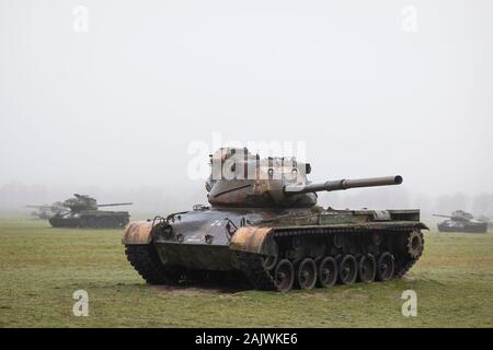 Abandoned derelict American tanks in a field with mist in Germany Stock Photo