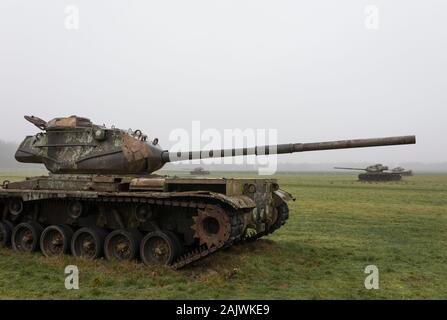 Abandoned derelict American tanks in a field with mist in Germany Stock Photo