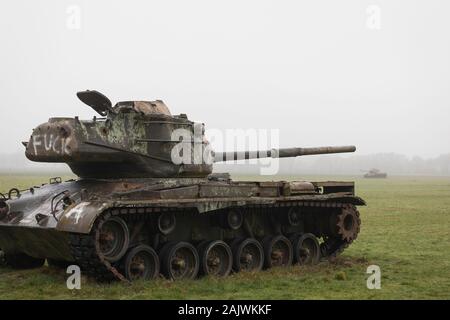 Abandoned derelict American tanks in a field with mist in Germany Stock Photo