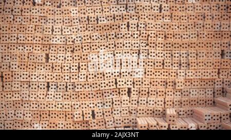 Blur of A group of construction brick or Pile of clay bricks put in neat order, used for construction material store outdoor at building site. Constru Stock Photo