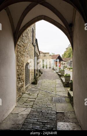 Arch and path to the Abbey shop and entrance seen from the street. Glastonbury, Somerset, England, UK, Britain Stock Photo