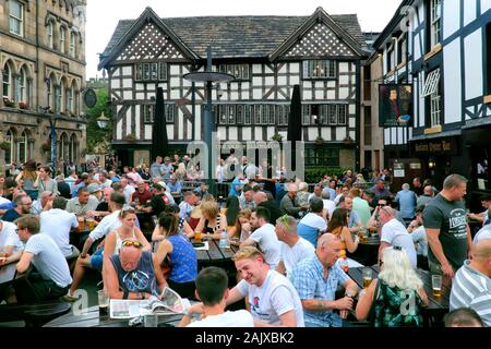 Old Wellington Inn & Sinclair's Oyster Bar, busy with people drinking in beer garden outdoors, Manchester, England, UK, Europe Stock Photo