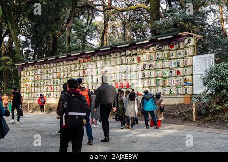TOKYO, JAPAN - FEBRUARY 7, 2019: Unidentified people  looking at traditional sake barrels wrapped in straw by Meiji Shrine. These sake barrels are off Stock Photo