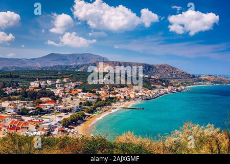 Greek holidays, beautiful Kalyves village with turquoise sea in Crete island, Greece. View of Kalyves beach, Crete. Tourists relaxing on the beach and Stock Photo