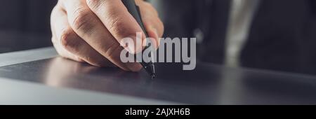 Wide view image of illustrator or designer using stylus pen working on tablet. Closeup view. Stock Photo