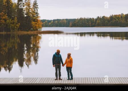 Couple in love holding hands walking travel family lifestyle romantic dating relationship man and woman standing on pier outdoor enjoying lake and aut