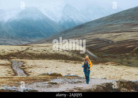 Woman with baby carrier traveling hiking family healthy lifestyle mother and child active vacations outdoor in Norway  Rondane park mountains Stock Photo