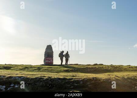 A young couple hill walking at Port Eynon, Gower Peninsula, Wales Stock Photo