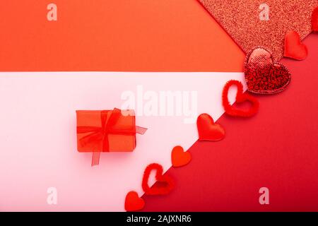 Valentines day card with Gift. Red background with hearts present, red ribbon. Concept of Valentine Day Love Romance Heart. Valentines day composition Stock Photo