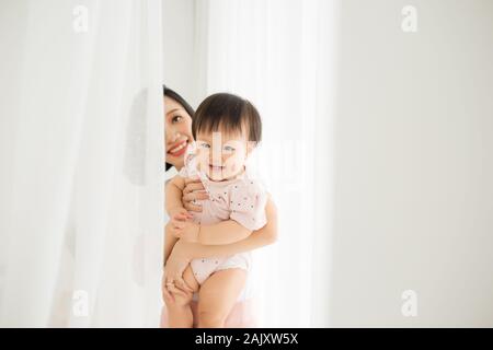 Mom and her daughter child girl are playing, smiling and hugging. Family holiday and togetherness.