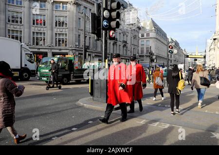 Chelsea Pensioners in red coats crossing Oxford Street at Oxford Circus in London England UK  KATHY DEWITT Stock Photo