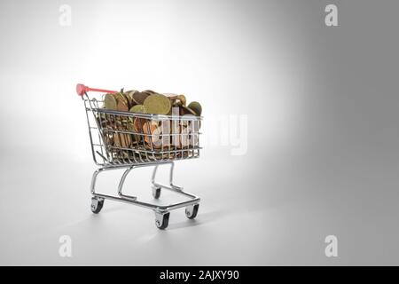 Wide Angle View of Tiny Shopping Trolley Full of Euro Coins on White Stock Photo
