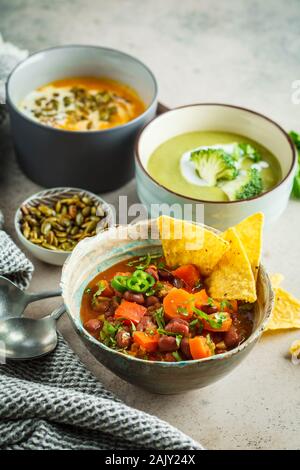 Set of healthy vegan soups. Mexican bean soup, broccoli cream soup and mashed pumpkin soup. Stock Photo