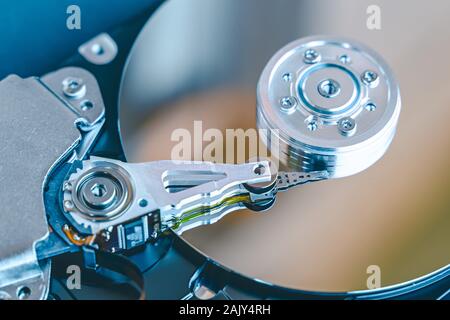 Hard disk drive platter.Disassembled hard drive from the computer with mirror effect. HDD. Detail of writing/reading head on actuator arm and axis, sp Stock Photo