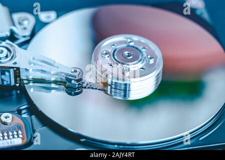 Hard disk drive platter.Disassembled hard drive from the computer with mirror effect. HDD) .Detail of writing/reading head on actuator arm and axis, s Stock Photo