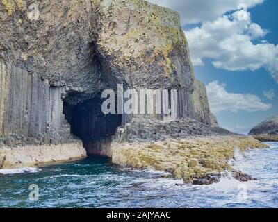 Fingal's Cave surrounded by columns of jointed volcanic basalt rocks in which the vertical joints form polygonal columns, on the island of Staffa Stock Photo