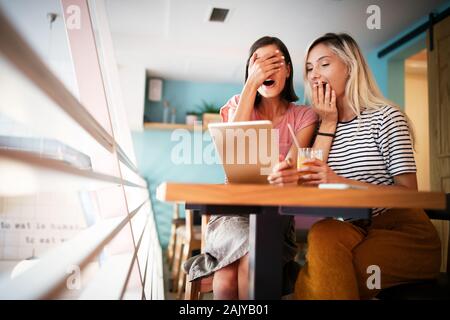 Young female friends surfing the internet and having fun together Stock Photo