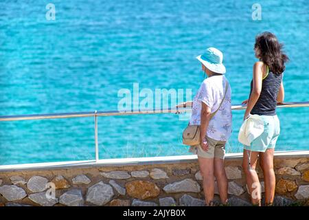 Mil palmeras, Spain, August 3, 2019: Back view of two tourists looking at horizon over the sea on summer vacations relaxing on the beach.