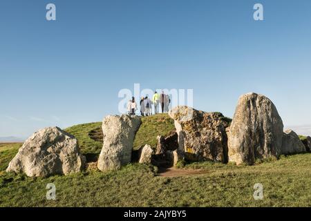 A tour group viewing West Kennett (or Kennet) Long Barrow near Avebury, Wiltshire, UK, a Neolithic burial mound or chambered tomb built around 3700 BC Stock Photo