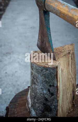 splittting wood with an ond hand axe.,close up.preparing for winter. Stock Photo