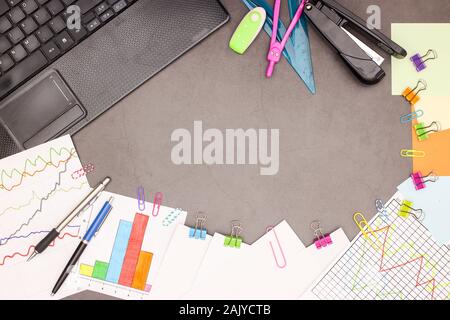 Lap top, statistics plans and office supplies on grey background Stock Photo