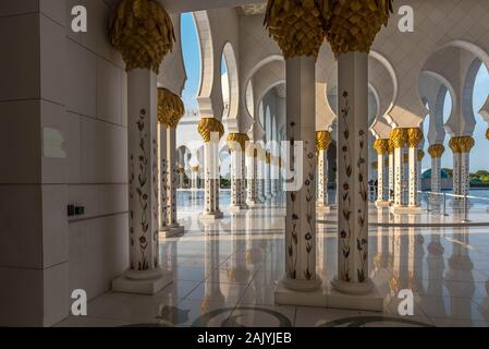 Abu Dhabi, United Arab Emirates: A colonnade of Abu Dhabi Sheikh Zayed Mosque (also known as Grand Mosque) marble twin columns and golden capitals Stock Photo