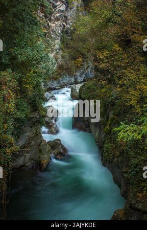 Long exposure image of a colorful mountain stream in a narrow canyon Stock Photo