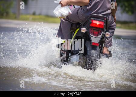 Splash by a motorcycle as it goes through flood water Stock Photo