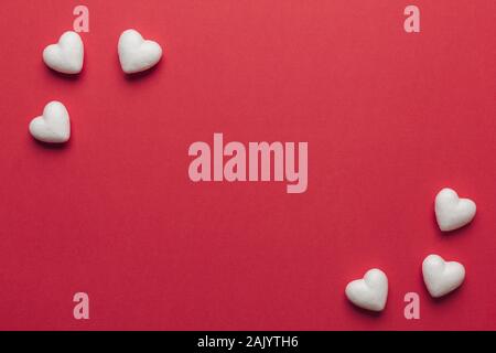 Stock photo of small white hearts on a red background. Hearts in the corners with a space for text Stock Photo